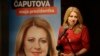 FILE - Presidential candidate Zuzana Caputova addresses the media following the first round of presidential elections, in Bratislava, Slovakia, March 16, 2019. The poster reads "Caputova is my president."