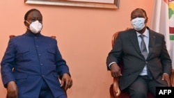 Ivory Coast President Alassane Ouattara, right, and former president and opposition leader Henri Konan Bedie have their first meeting since the national election in Abidjan on Nov. 11, 2020.