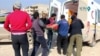 FILE - An injured person is carried on stretcher into an ambulance after an airstrike on location targeted by government and aliied forces, in Khan Sheikhoun, Idlib, Syria, Feb. 26, 2019,