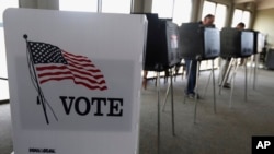 FILE - Voters cast their ballots in the Illinois primary in Hinsdale, March 18, 2014.