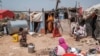 FILE - A mother of 8 children exits part of her house as her children stay around in an informal settlement of internally displaced people in the outskirts of the city of Hargeisa, Somaliland, on September 16, 2021.