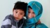 Murtaza Ahmadi, 7, an Afghan Lionel Messi fan and his mother, Shafiqa Ahmadi, 38, pose for a picture at their house in Kabul, Afghanistan, Dec. 8, 2018.