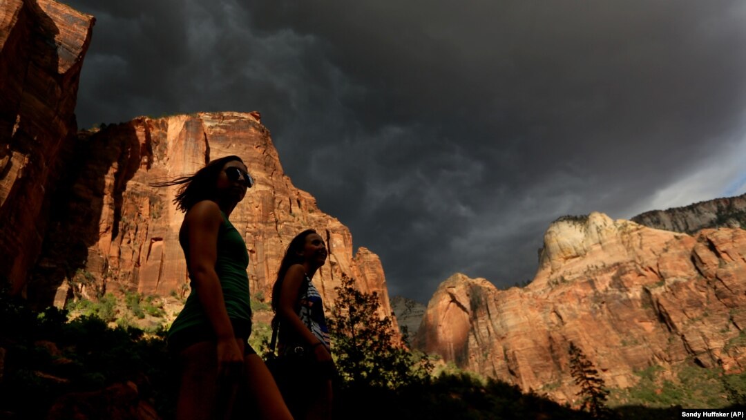 Hikers look up at a fast moving storm as it makes its way through Zion National Park outside of Springdale, Utah. 