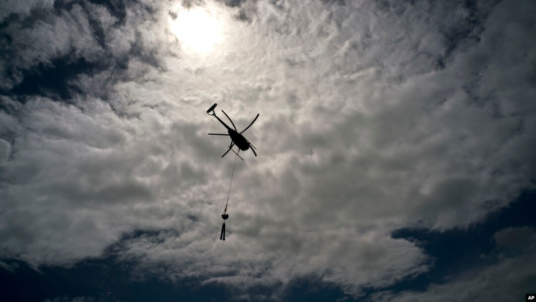 A helicopter from Whitefish Energy Holdings flies to power line towers for repairs after the passing of Hurricane Maria in Barceloneta, Puerto Rico, Oct. 15, 2017. 