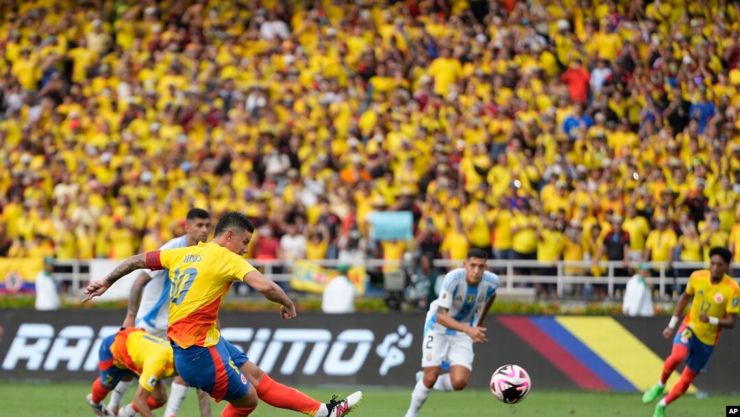 El colombiano James Rodríguez marca un penal, el segundo gol de su equipo, contra Argentina durante un partido de fútbol de clasificación para la Copa Mundial de la FIFA 2026. AFP