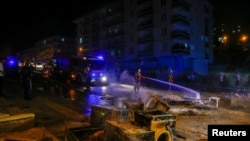 A firefighter extinguishes goods of a shop burnt during riots against refugees in Ankara, Turkey, Aug. 11, 2021.