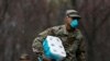 A member of Joint Task Force 2 wears a face mask while carrying paper towels in New Rochelle, New York, March 23, 2020.