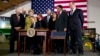 President Barack Obama, surrounded by members of Congress, signs the Farm Bill, Feb. 7, 2014, at Michigan State University in East Lansing, Michigan.