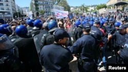 Police officers prevent demonstrators from marching during a May Day protest in Algiers, Algeria, May 1, 2019. 