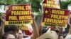 Protesters display placards during their rally outside the Chinese Consulate at the financial district of Makati city, east of Manila, Philippines, April 16, 2012.