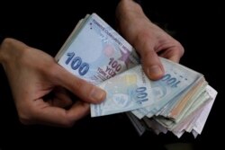 FILE PHOTO: A merchant counts Turkish lira banknotes at the Grand Bazaar in Istanbul, Turkey, March 29, 2019.