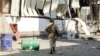 FILE - Members of the Yemeni pro-government forces walk through destruction in an industrial district in the eastern outskirts of the port city of Hodeida on Nov. 18, 2018, during the ongoing battle for control of the city from the Houthi rebels. 