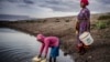 FILE: Martha Kasafi (right) and her daughter, both refugees from Democratic Republic of Congo, collect water for their vegetable crops at a water pan in Kalobeyei settlement for refugees in Turkana County, Kenya on Oct. 2, 2019.