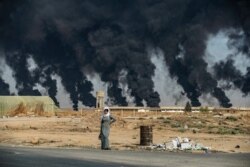 Smoke billows from burning tires to decrease visibility for Turkish warplanes on the outskirts of the town of Tal Tamr, Syria, along the border with Turkey in the northeastern Hassakeh province.