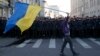 A man with a Ukrainian flag walks past riot police standing guard during an anti-war rally in Moscow, Sept. 21, 2014. 