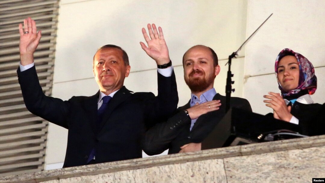 FILE - Turkish PM Tayyip Erdogan, accompanied by his son Bilal and daughter Sumeyye, greets his supporters at the AK Party headquarters in Ankara, March 30, 2014.