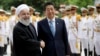 Japanese Prime Minister Shinzo Abe, center, shakes hands with Iranian President Hassan Rouhani during the official arrival ceremony, at the Saadabad Palace in Tehran, Iran, June 12, 2019.