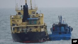 FILE - This photo released by Japan's Ministry of Defense shows what it says is the North Korean-flagged tanker Yu Jong 2, left, and the Min Ning De You 078 lying alongside in the East China Sea, Feb. 16, 2018. China said it was "highly concerned" about a