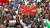 FILE - A man holds a banner against the United Nations Multidimensional Integrated Stabilization Mission in Mali and Barkhane, an operation led by the French military against Islamist groups in Africa's Sahel region, in Bamako, Mali, Aug. 21, 2020. 