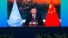 Media staff members watch a live image of China's President Xi Jinping speaking at the media center of the UN Biodiversity Conference (COP 15) in Kunming, in China's southwestern Yunnan province on Oct. 12, 2021.