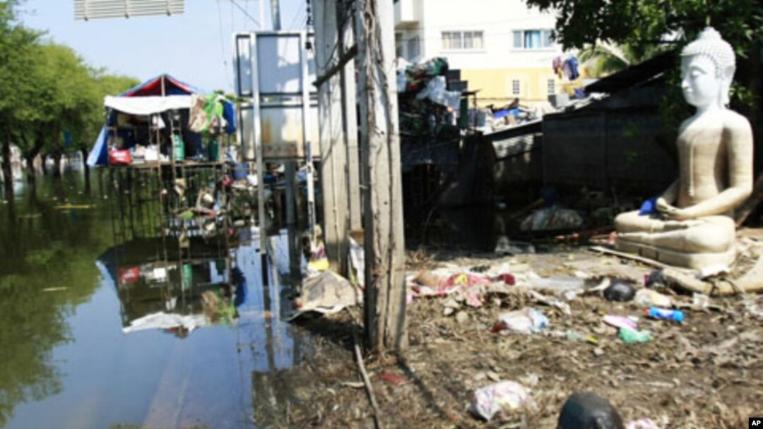 A Buddha's statue sits amidst trash at a half-flooded street corner in Ayutthaya province, central Thailand November 8, 2011.