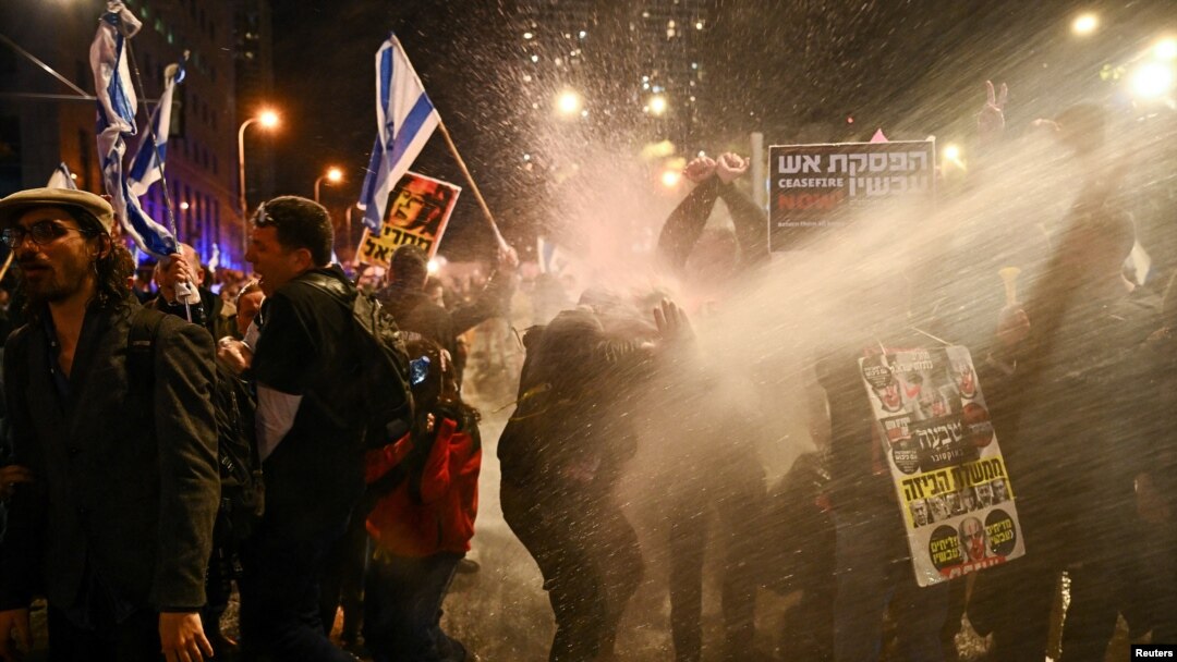 Manifestantes reaccionan cuando la policía usa cañones de agua para dispersarlos durante una protesta contra el gobierno del primer ministro israelí, Benjamin Netanyahu, en medio del conflicto en curso entre Israel y Hamás, en Tel Aviv, Israel, el 24 de febrero de 2024.