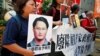Pro-democracy protesters carry a photo of detained Taiwanese rights activist Lee Ming-Che (L) and other activists during a demonstration in Hong Kong, China, Sept. 11, 2017.