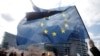 FILE - FILE - A demonstrator holds a European flag during a protest in front of the European Parliament in Strasbourg, France, March 26, 2019. 