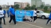 Two participants hold banner during ability awareness march, July 29, 2021. (Timothy Obiezu/VOA)