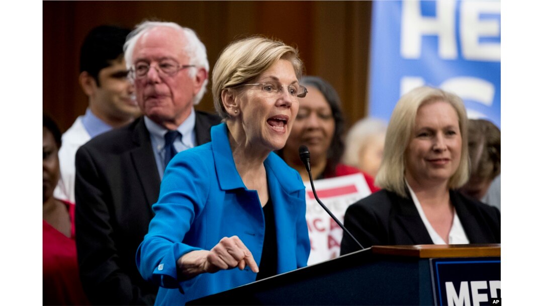 FILE - Sen. Elizabeth Warren, D-Mass., center, accompanied by Sen. Bernie Sanders, I-Vt., left, and Sen. Kirsten Gillibrand, D-N.Y., right, speaks during a news conference on Capitol Hill in Washington, Sept. 13, 2017.