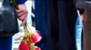 In this grab taken from footage provided by the Russian State Atomic Energy Corporation ROSATOM press service, a woman holds roses as people gather for the funerals of five Russian nuclear engineers killed by a rocket explosion in Sarov, Aug. 12, 2019.