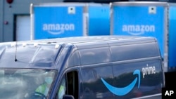 FILE: An Amazon Prime logo appears on the side of a delivery van as it departs an Amazon Warehouse location in Dedham, Mass. on Oct. 1, 2020.