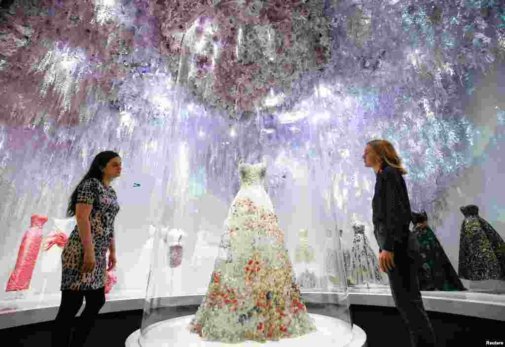 Gallery assistants pose for members of the media during a photocall for the &quot;Christian Dior: Designer of Dreams&quot; exhibition at the Victoria &amp; Albert (V&amp;A) Museum in London.