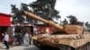 Turkish soldiers atop a tank patrol the northwestern city of Afrin, Syria, during a Turkish government-organized media tour into northern Syria, March 24, 2018.