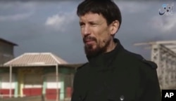 This still taken from video released Dec 7, 2016 by the Islamic State's Amaq news agency, shows captive British photojournalist John Cantlie in what appeared to be central Mosul, Iraq.