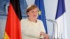 German Chancellor Angela Merkel, left and French President Emmanuel Macron talk in the garden of Meseberg Castle, the German government's guest house in Meseberg, Germany, June 29, 2020.