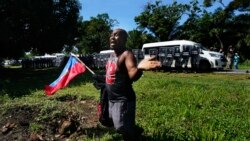Yon migran Ayisyen ki kenbe drapo peyi li ap mande otorite Meksiken yo pa arete'l pandan li nan wout pou'l al sou frontye Meksik pataje ak Etazuni nan Chiapas, Meksik, 2 Sept. 2021.