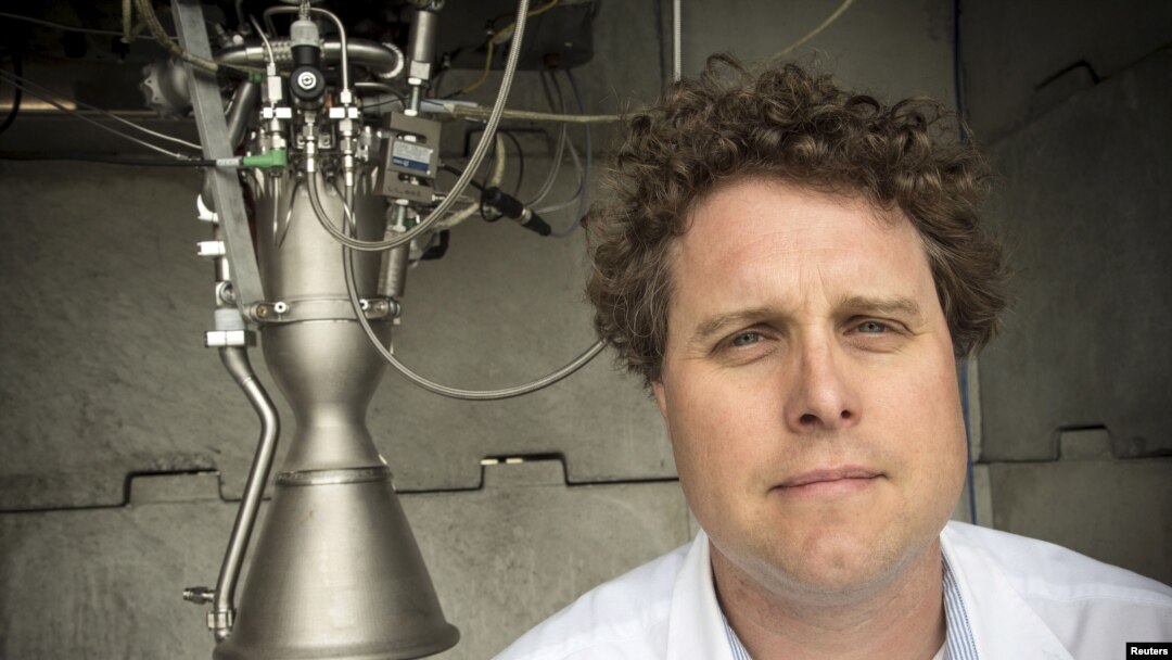 FILE - Rocket Lab CEO Peter Beck poses alongside a Rutherford rocket engine in Auckland, New Zealand, Oct. 20, 2015. 