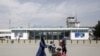 FILE - Afghan passengers walk in front of Hamid Karzai International Airport in Kabul, Afghanistan, March 29, 2016. 