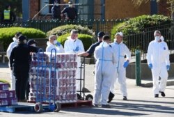 FILE - Response personnel prepare to distribute goods to residents inside a public housing tower, locked down in response to an outbreak of the coronavirus disease (COVID-19), in Melbourne, Australia, July 9, 2020.