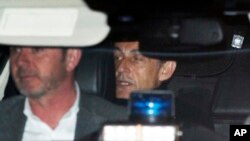 Former French President Nicolas Sarkozy, right, leaves the police station where he was held, in Nanterre, outside Paris, March 21, 2018. Sarkozy was questioned by police for a second day over allegations he took millions of euros in illegal campaign funding from the late Libyan leader Moammar Gadhafi.