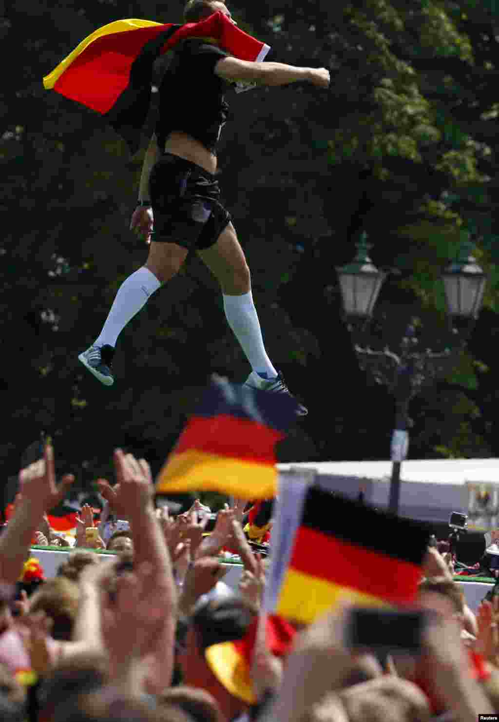 Germany's goalkeeper Manuel Neuer jumps in the air during celebrations to mark the team's 2014 Brazil World Cup victory, at the Fan Mile public viewing zone, in Berlin, July 15, 2014.
