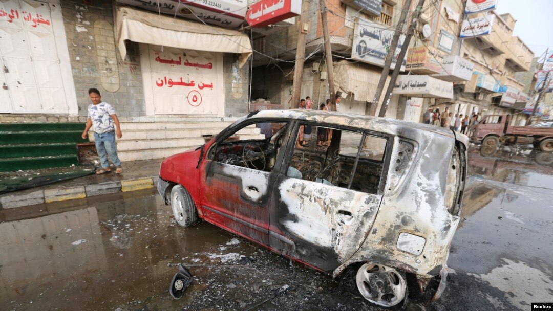 FILE - A man stands by a car damaged by a strike near al-Thawra Hospital in Hodeidah, Yemen, Aug. 2, 2018.