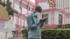 FILE - A man wears a mask while walking outside the entrance to the Yaounde General Hospital in Yaounde, March 6, 2020.