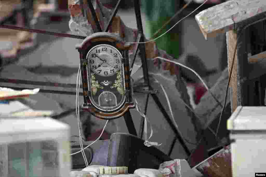 A clock is seen amidst the debris of a collapsed house after a strong 6.6 magnitude earthquake, at Longmen village, Lushan county, Ya'an, Sichuan province, Apr. 20, 2013.