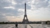 FILE - In this April 24, 2020, photo, a man wears a mask to protect against the spread of the coronavirus as he walks along the Trocadero square close to the Eiffel Tower in Paris.