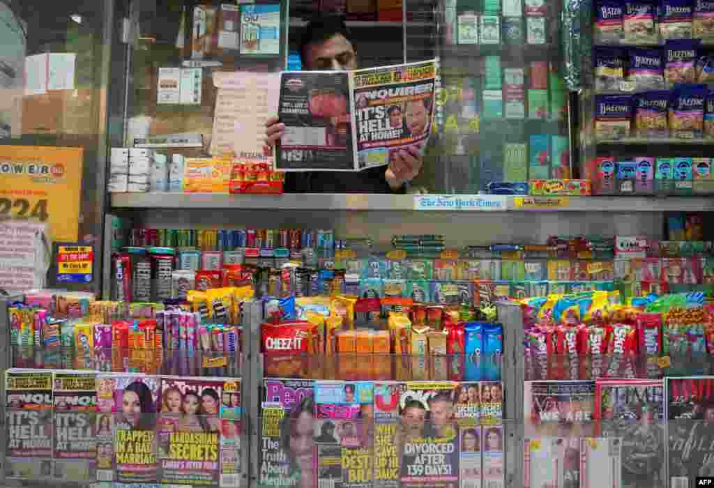 A newspaper vendor on Third Avenue in midtown New York City displays a copy of the National Enquirer for a photographer at his news stand. The publisher of the National Enquirer said Friday it would open an internal probe of accusations by Amazon&#39;s Jeff Bezos over blackmail and extortion by the tabloid.