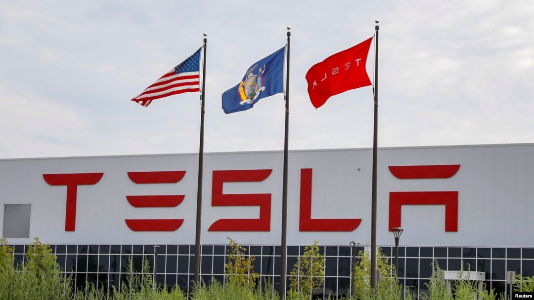 Flags fly over the Tesla Inc. Gigafactory 2, which is also known as RiverBend, a joint venture with Panasonic to produce solar panels and roof tiles in Buffalo, New York, U.S., Aug. 2, 2018. 