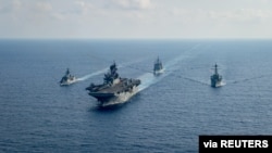 FILE - A Royal Australian Navy guided-missile frigate (L) sails with three US Navy ships in the South China Sea, April 18, 2020. (US Navy photo)