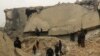 Civil defense members and other people inspect a damaged mosque after an airstrike on the village of al-Jinah, Aleppo province, in northwest Syria, March 17, 2017.